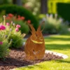 Silhouette d'animal en acier corten représentant un lapin dans un jardin